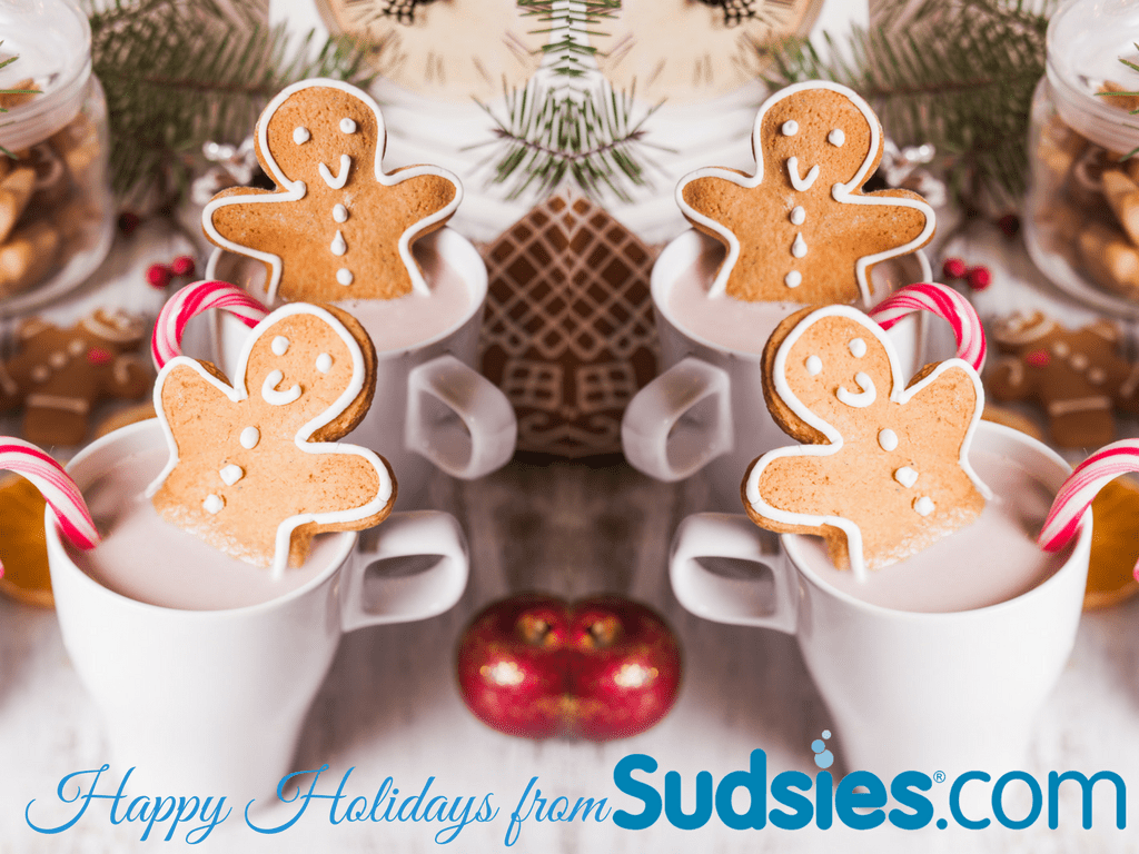 Image of 4 coffee cups with 4 gingerbread man cookies and 4 candy canes with one in each cup. Close up of table scape with clock, apple and waffle cookie.