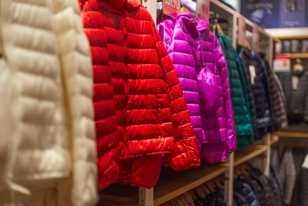 Row of puffy winter coats hanging in a store display
